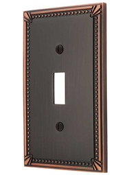 Imperial Bead Single Toggle Switch Plate in Aged Bronze.
